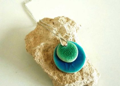 Collar-Disco-Cristalino-Plata-Tuquesa-y-Verde. Menorceràmik elabora trabajos en cerámica inspirándose en el color del Mediterráneo.