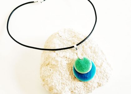 El Collar Disco Cristalino se caracteriza por la gran armonía que resulta de combinar  dos suaves tonos acristalados, colores que evocan el Mediterrraneo. 