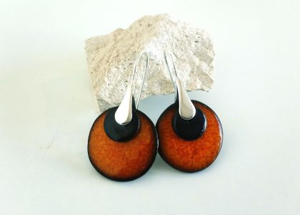 Pendientes de color anaranjado volcánico , contrastados con una fina pieza de color negro brillante elaborados de manera artesanal uno a uno en la isla de Menorca